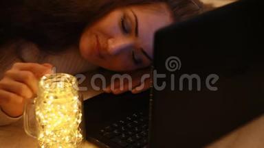 疲惫的女人在电脑上工作到深夜，闭上眼睛睡着了。